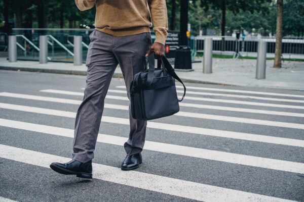 crop black man with bag walking on street
